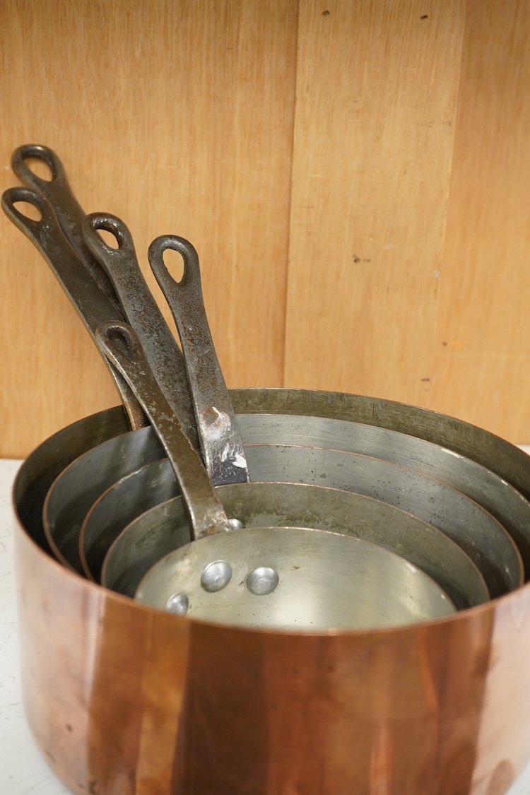 A graduated set five copper saucepans, signed Faucogney, largest 33cm wide